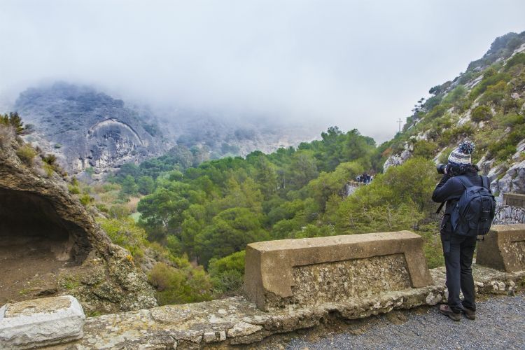 things to do in andalusia | One trekker woman walking along the Caminito del Rey path, Malaga, Spain. She is taking pictures with reflex camera