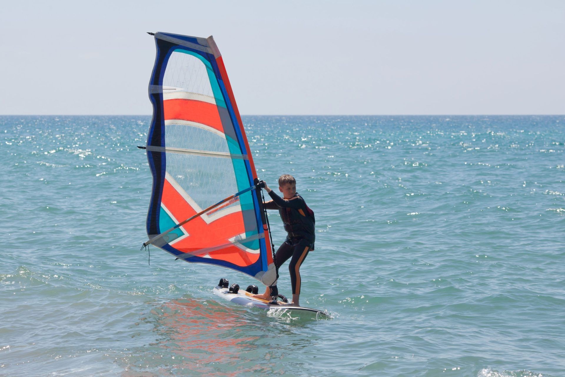 Windsurfing in a calm day with clear blue sky and Mediterranean Sea | family holiday in Mallorca