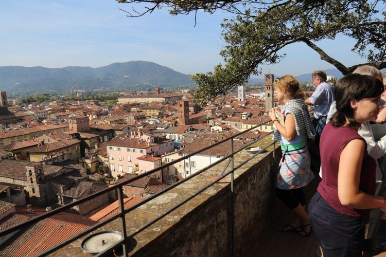 best group activities in Tuscany | Lucca, Italy - September 28, 2017: Tourists admire the view from the Torre Guinigi tower in Tuscany in Lucca, Italy on September 28, 2017