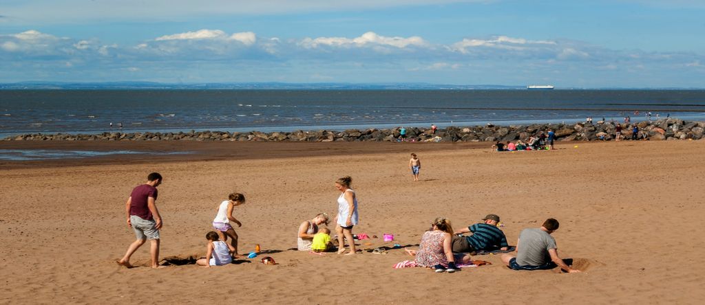 People walking and enjoying a summer day in a shoreside in Minehead, UK