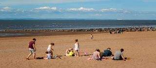 People walking and enjoying a summer day in a shoreside in Minehead, UK