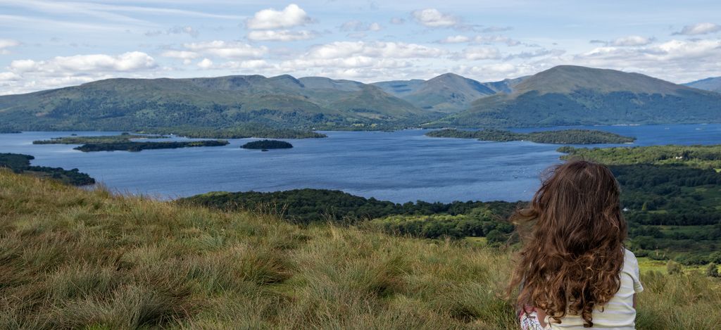 woman sitting overlooking a loch in Scotland