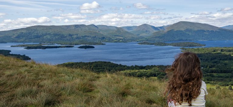 woman sitting overlooking a loch in Scotland