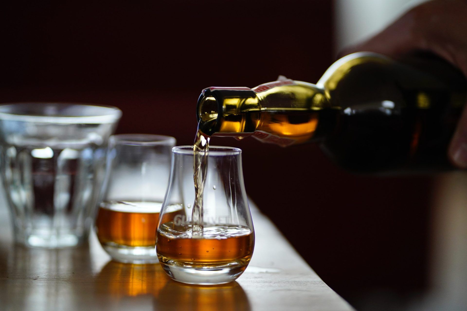 whisky being poured into two glasses - Scotland travel guide