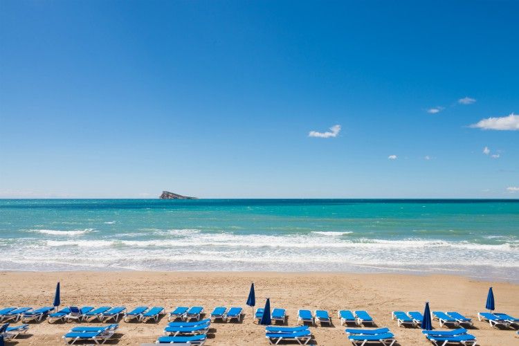 Benidorm beach with rows of deckchairs waiting for sunbathers
