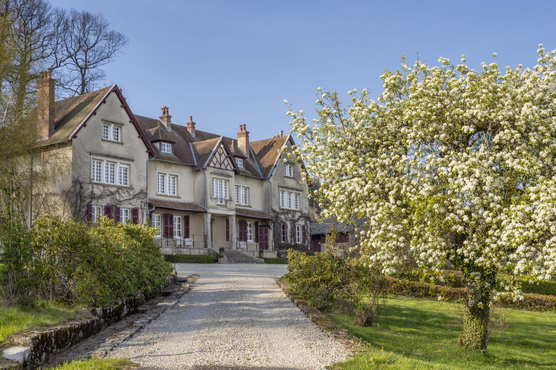 Exterior of large Victorian manor house with blossoming tree