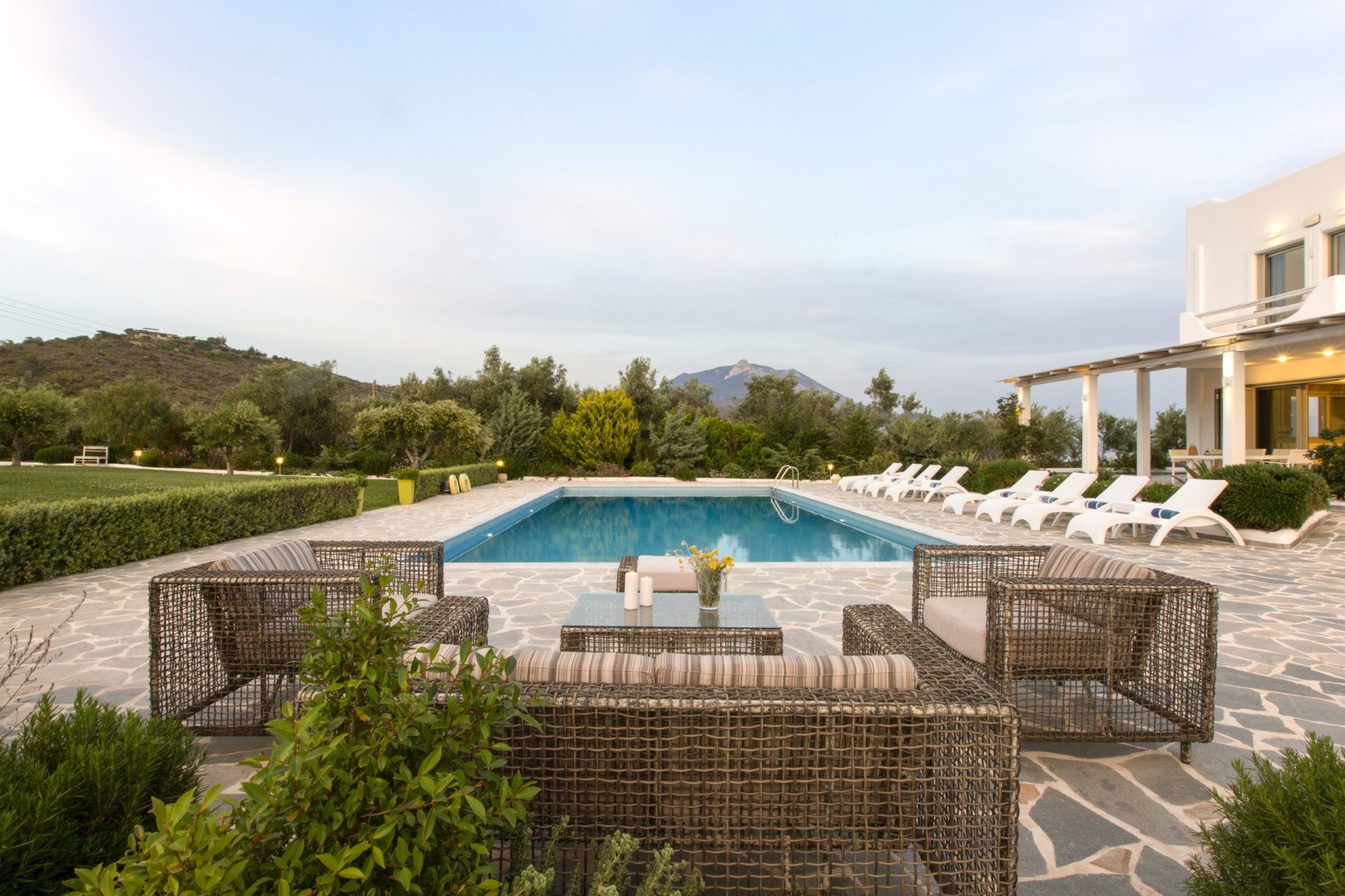Swimming pool with sun loungers and mountains in the background