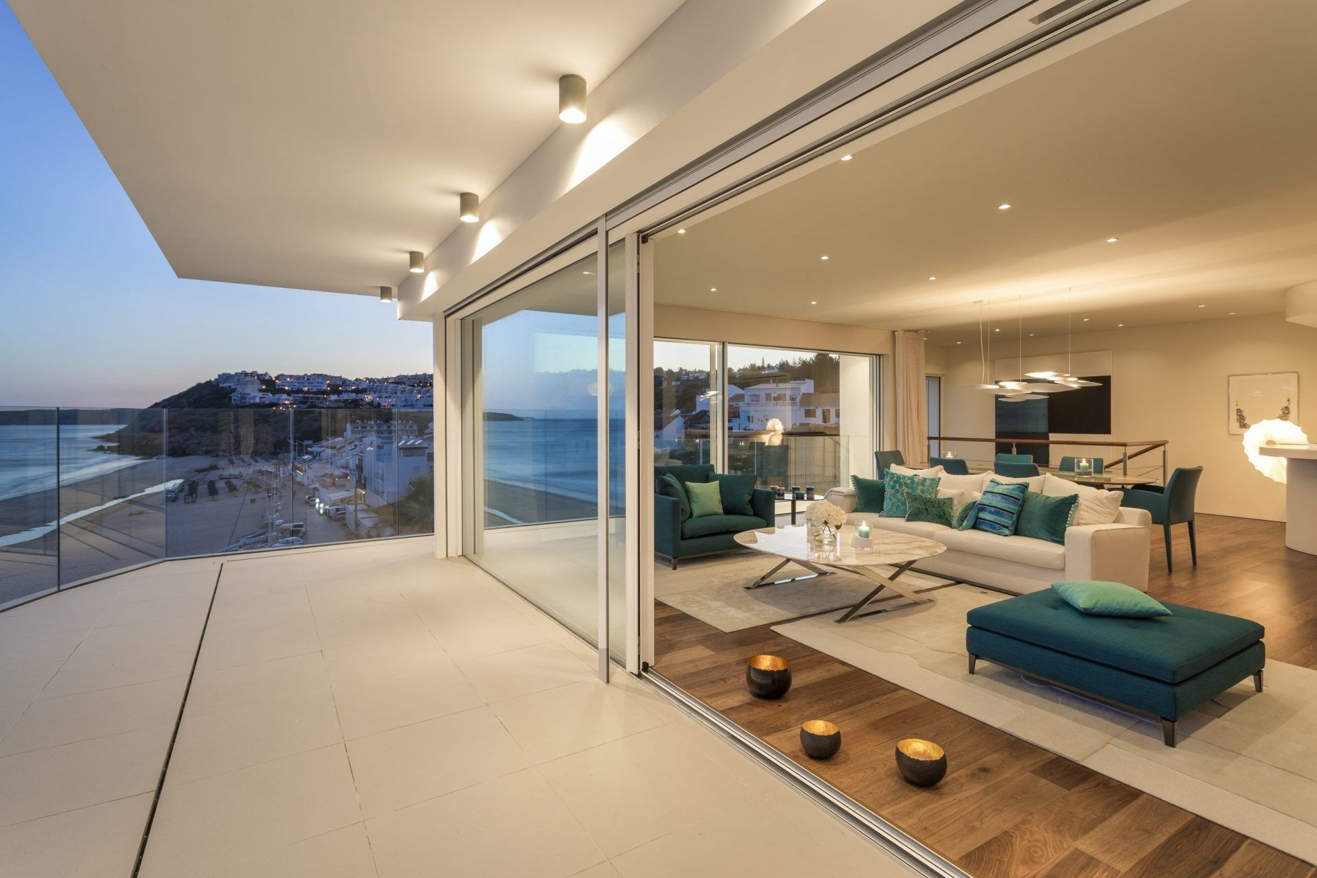 View of living room with night lights and view of beach from balcony