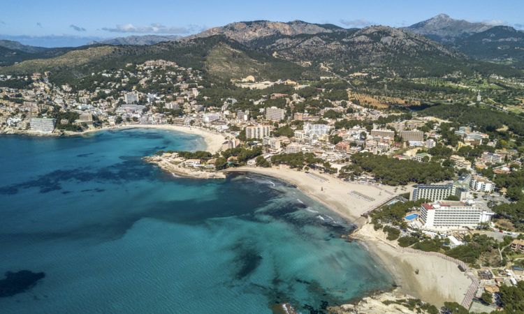 Aerial photograph of the three beaches of Paguera and their skykine, on a sunny summer day.