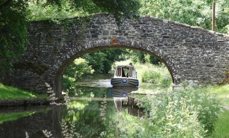 Boat travelling underneath a bridge in Monmoutshire