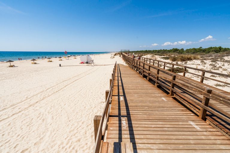 Wide Sandy Beach With Wooden Bridges In Monte Gordo, Algarve