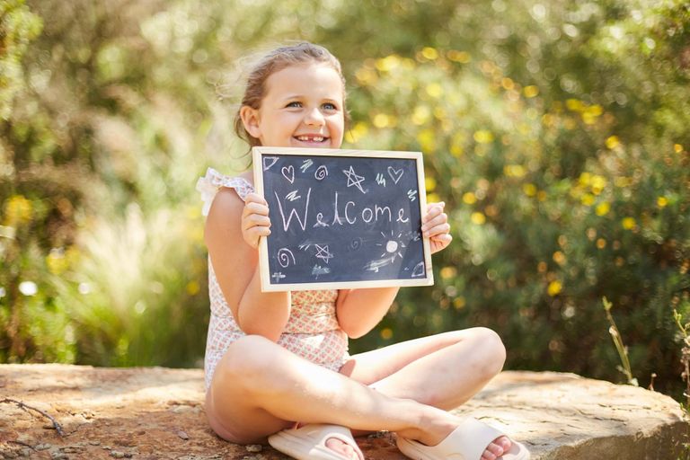 Young girl on holiday holding a chalkboard