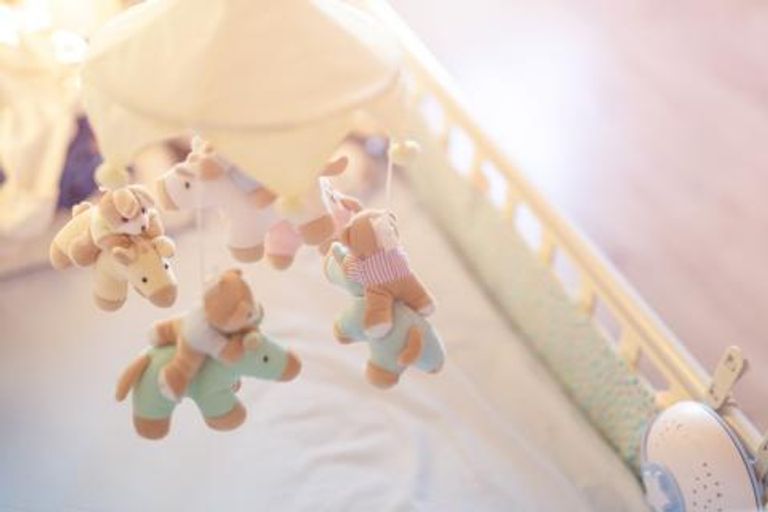 Children's toys hanging above a cat