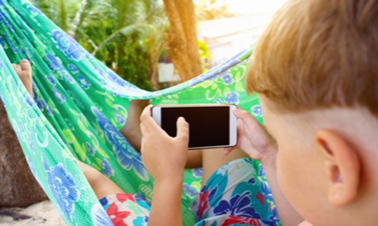 Child playing on a phone in a hammock