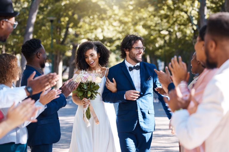Happy celebration and clapping for couple at wedding with excited, joyful and cheerful crowd of guests.