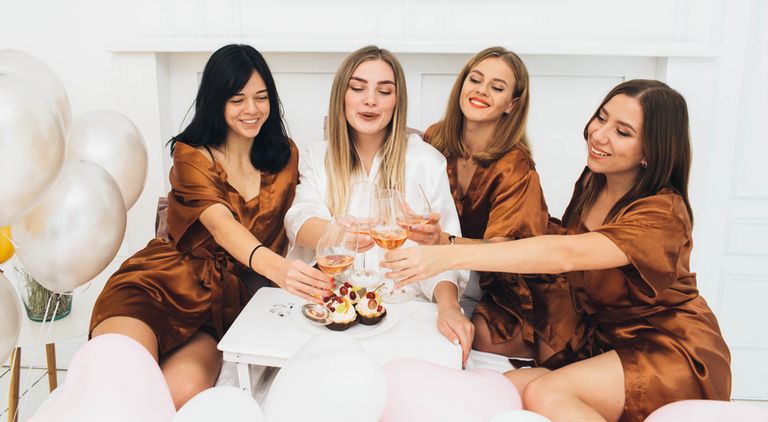 Women celebrating hen party, drinking alcohol and laughing