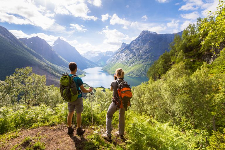 Tow hikers looking out to mountains and lake